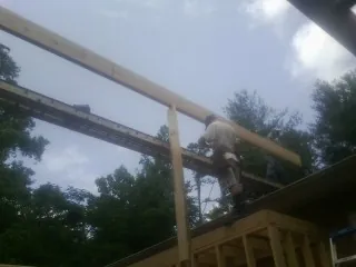 Carpenter setting a ridge beam over a new addition frame — Ice Dam Removal by Roofing Brothers in Lewisberry