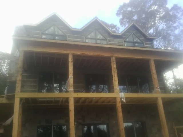 Dormers and porch framing on a large log home under construction — Roof Coating work by our crew in Lewisberry